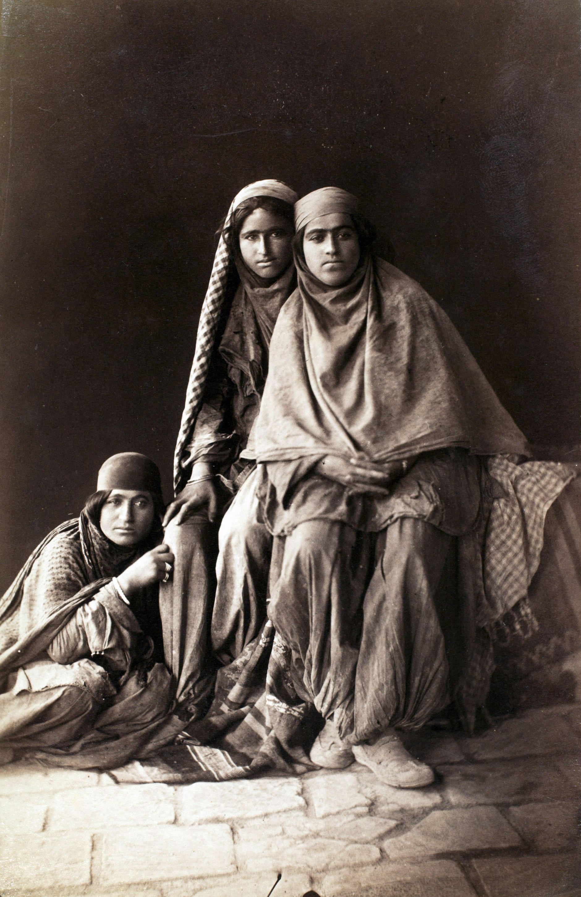 Three women tiredly look at Antoin Sevruguin as he photographs them in the late 19th century..jpeg